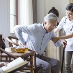 Nursing assistant taking care of senior man